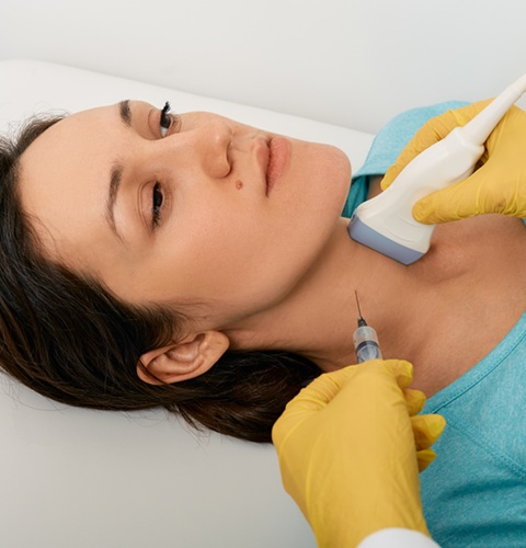 Thyroid nodule biopsy. Adult woman during fine needle aspiration biopsy guided ultrasonic and ultrasound specialist content-image